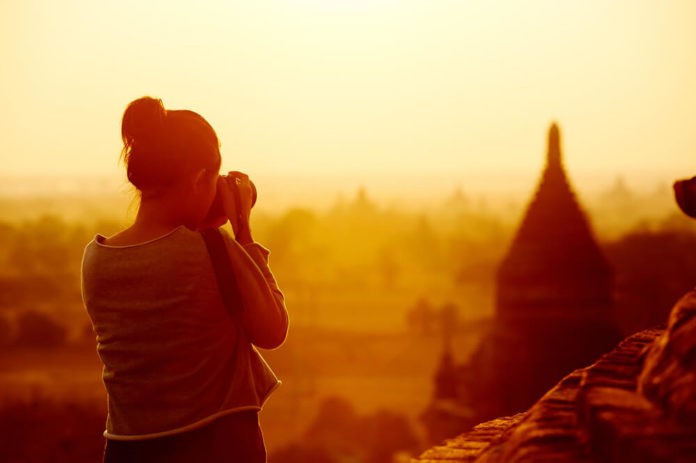 female traveler photographing temples at Bagan Myanmar Asia at sunrise