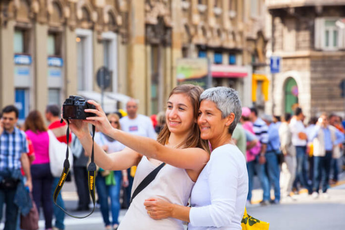 Mother and daughter taking selfie with entry level Nikon photo camera