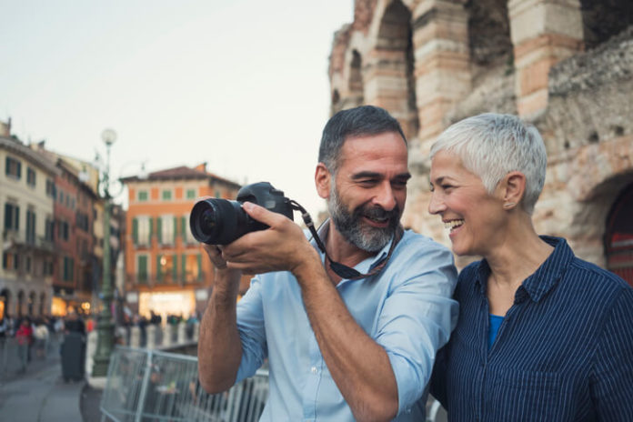 Mature couple as tourist using a camera in city Verona