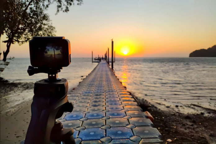 gopro alternative Action camera mounted on a tripod photograph the pier and sunrise on the beach